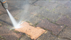 Outdoor floor worker cleaning with high pressure water jet to make patio look brand new