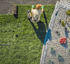 Man laying down artificial grass