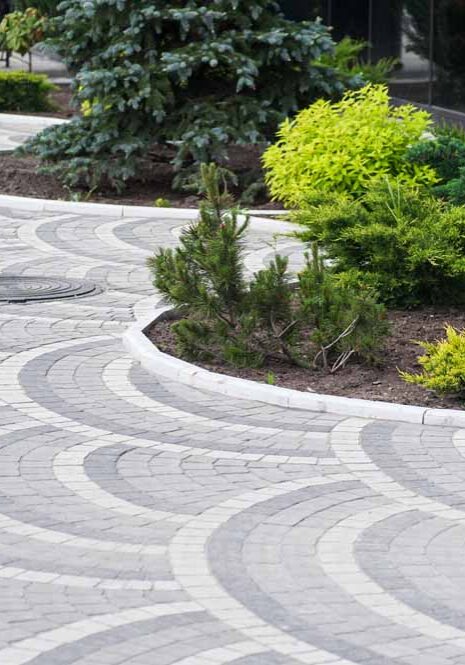 Gorgeous, multicolored paver driveway with lovely landscaping