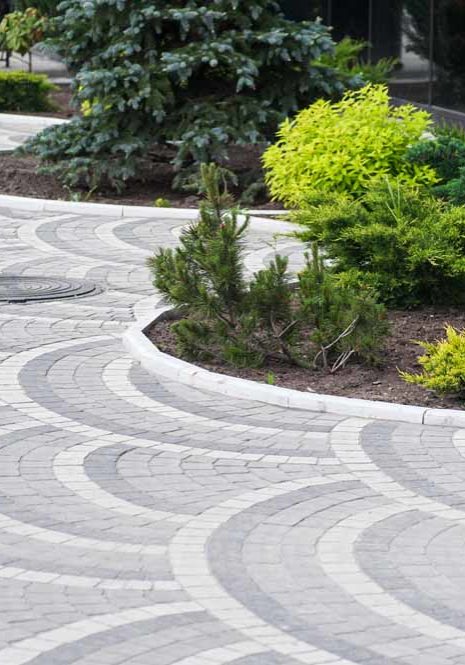 Gorgeous, multicolored paver driveway with lovely landscaping