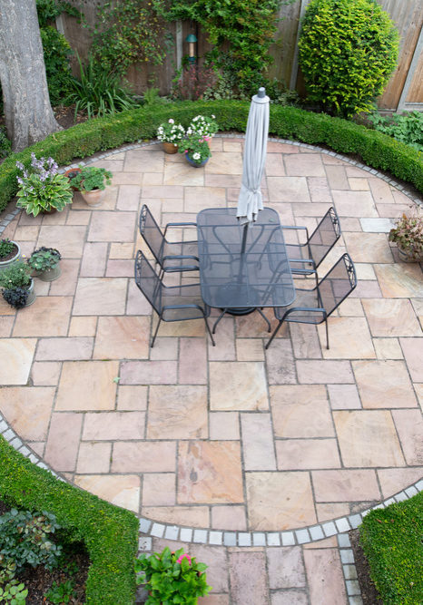 Arial view of circular stone patio surrounded by short hedges